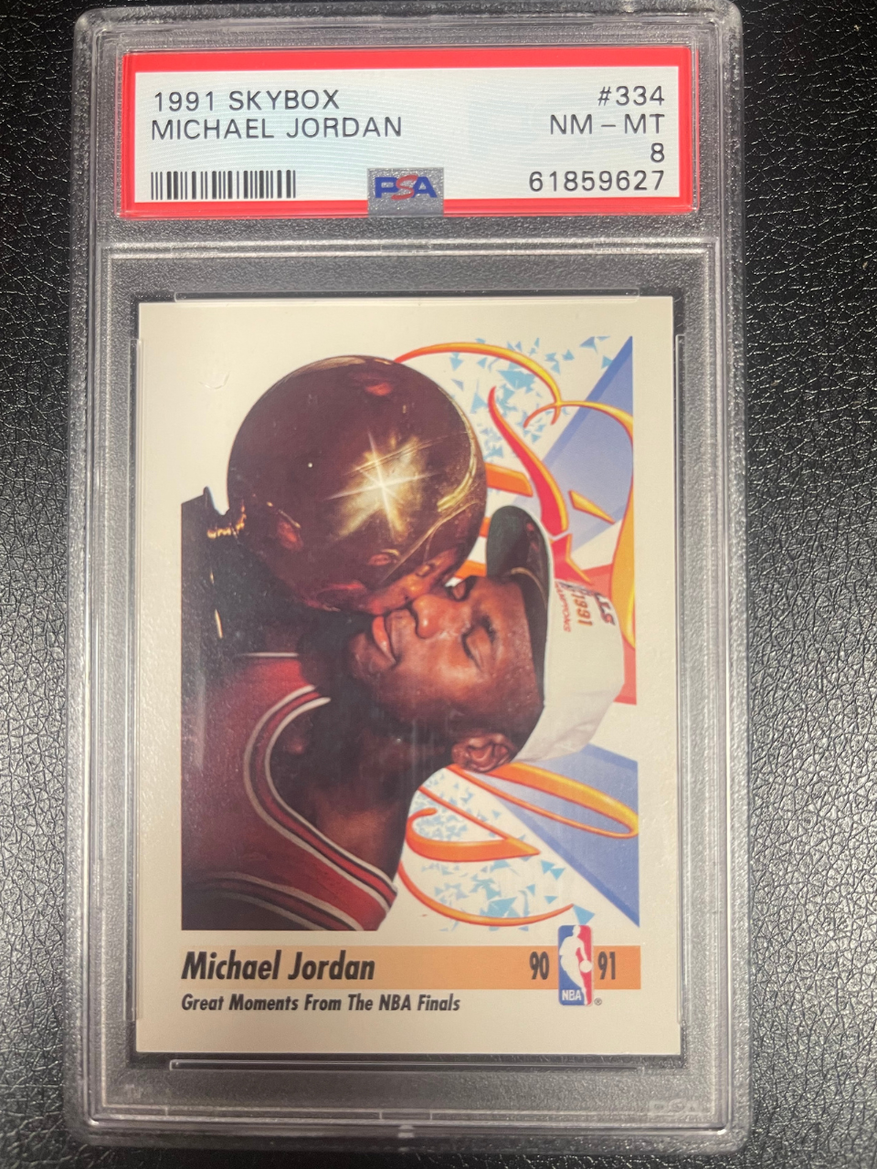 1991 SkyBox Michael Jordan #334 trading card, PSA graded NM-MT 8, showing Jordan kissing a trophy.