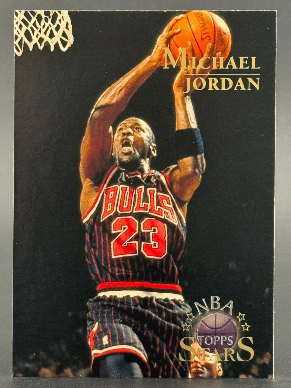 Trading card of Michael Jordan in a Bulls uniform shooting a basketball, with NBA Topps Stars logo.