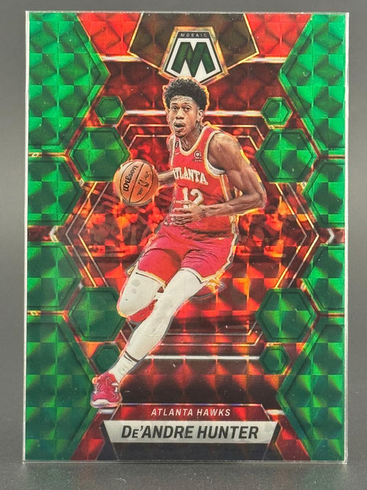 2022-23 Panini Mosaic De'Andre Hunter trading card in red and green holo finish, featuring him dribbling for the Hawks.