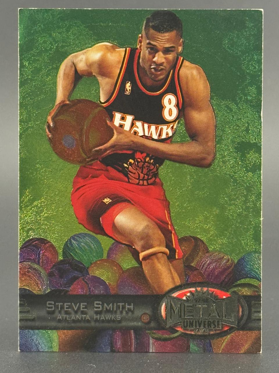 1997-98 Metal Universe Steve Smith trading card, Atlanta Hawks #8, featuring him holding a basketball over spheres.
