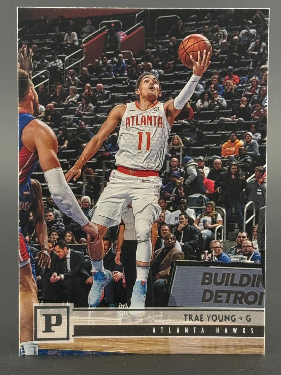 Trae Young Atlanta Hawks basketball card, driving to the basket with a basketball in his right hand.