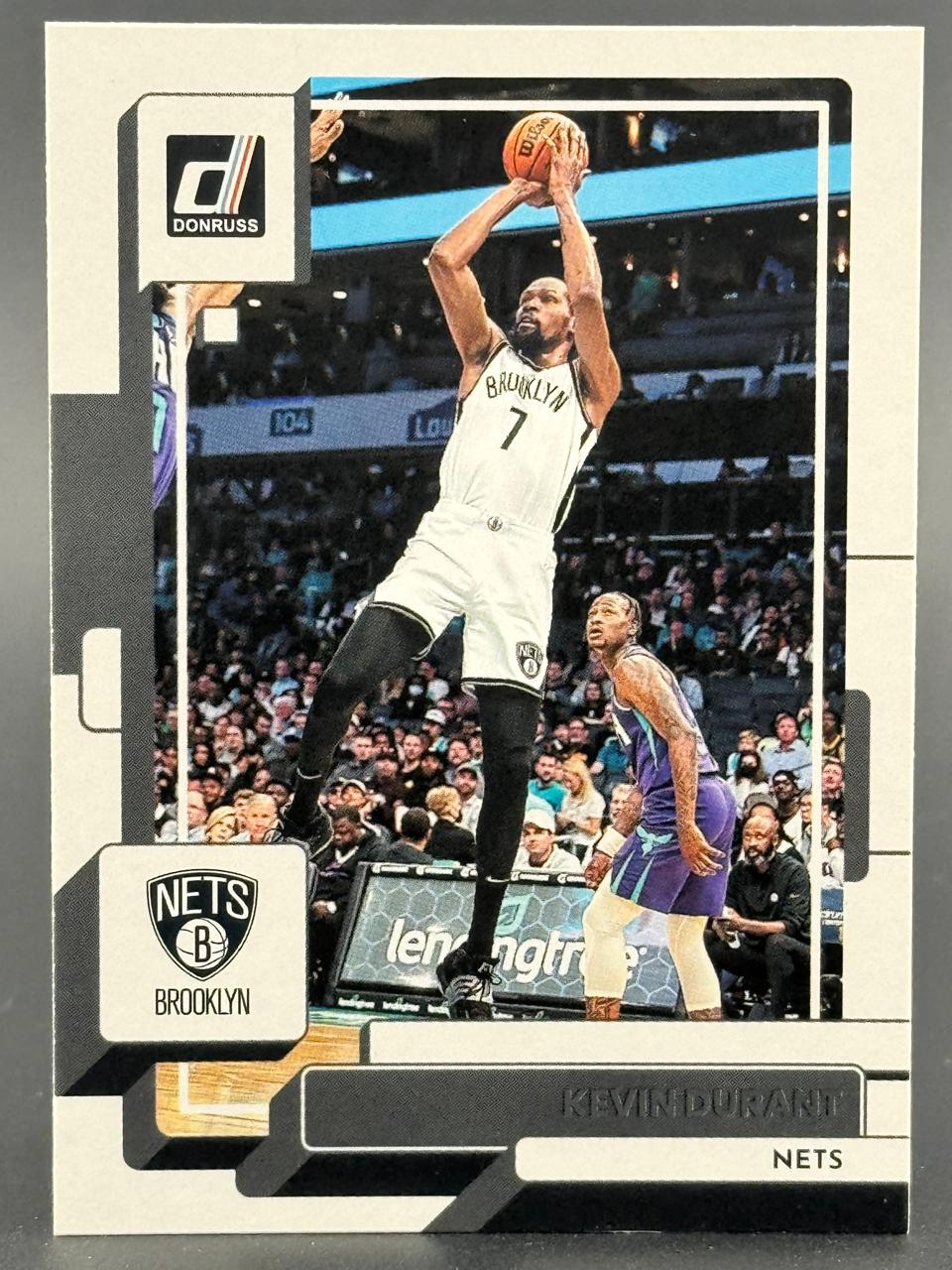 Kevin Durant 2021-22 Donruss basketball card featuring Durant in a Brooklyn Nets uniform shooting a jump shot.
