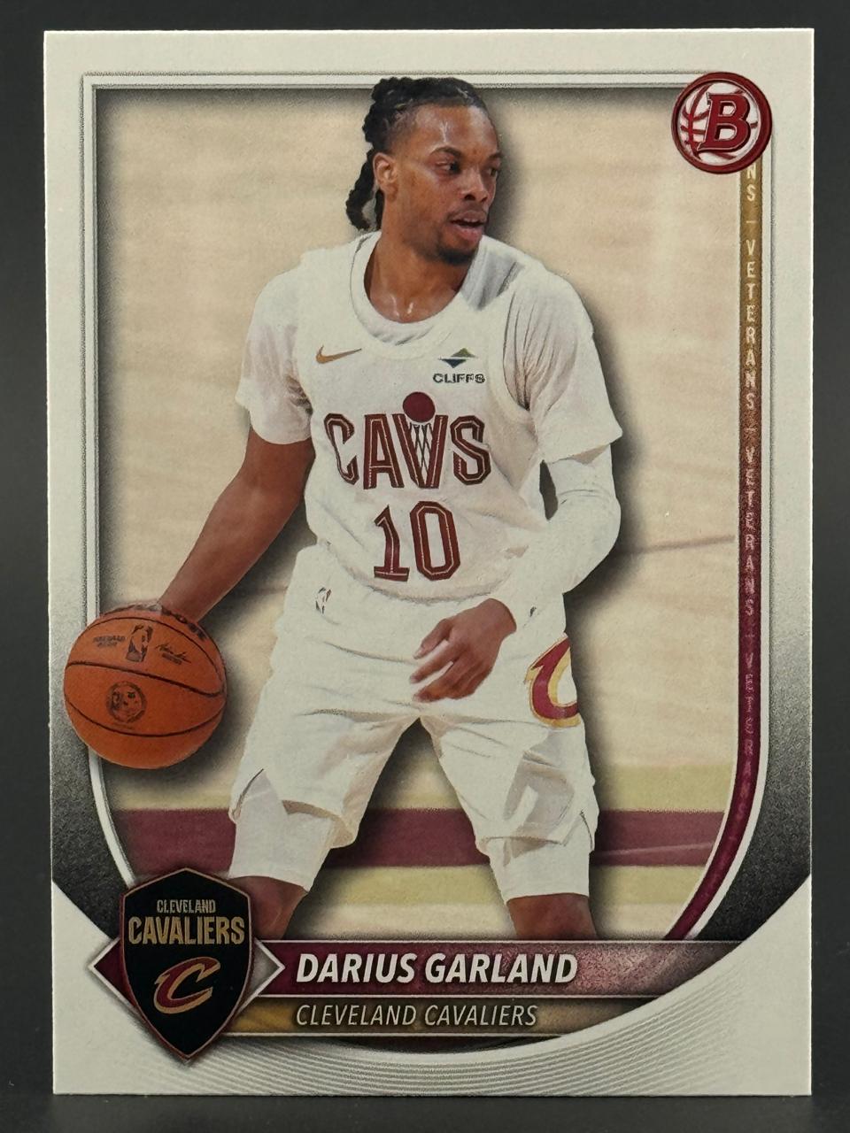 Trading card of Darius Garland in a white Cavaliers uniform dribbling a basketball.