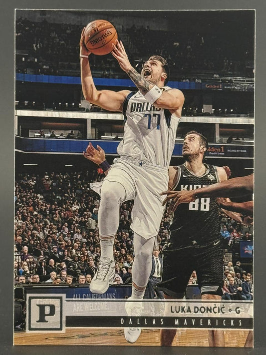 Luka Dončić basketball trading card featuring him in a white Dallas Mavericks uniform going up for a shot.