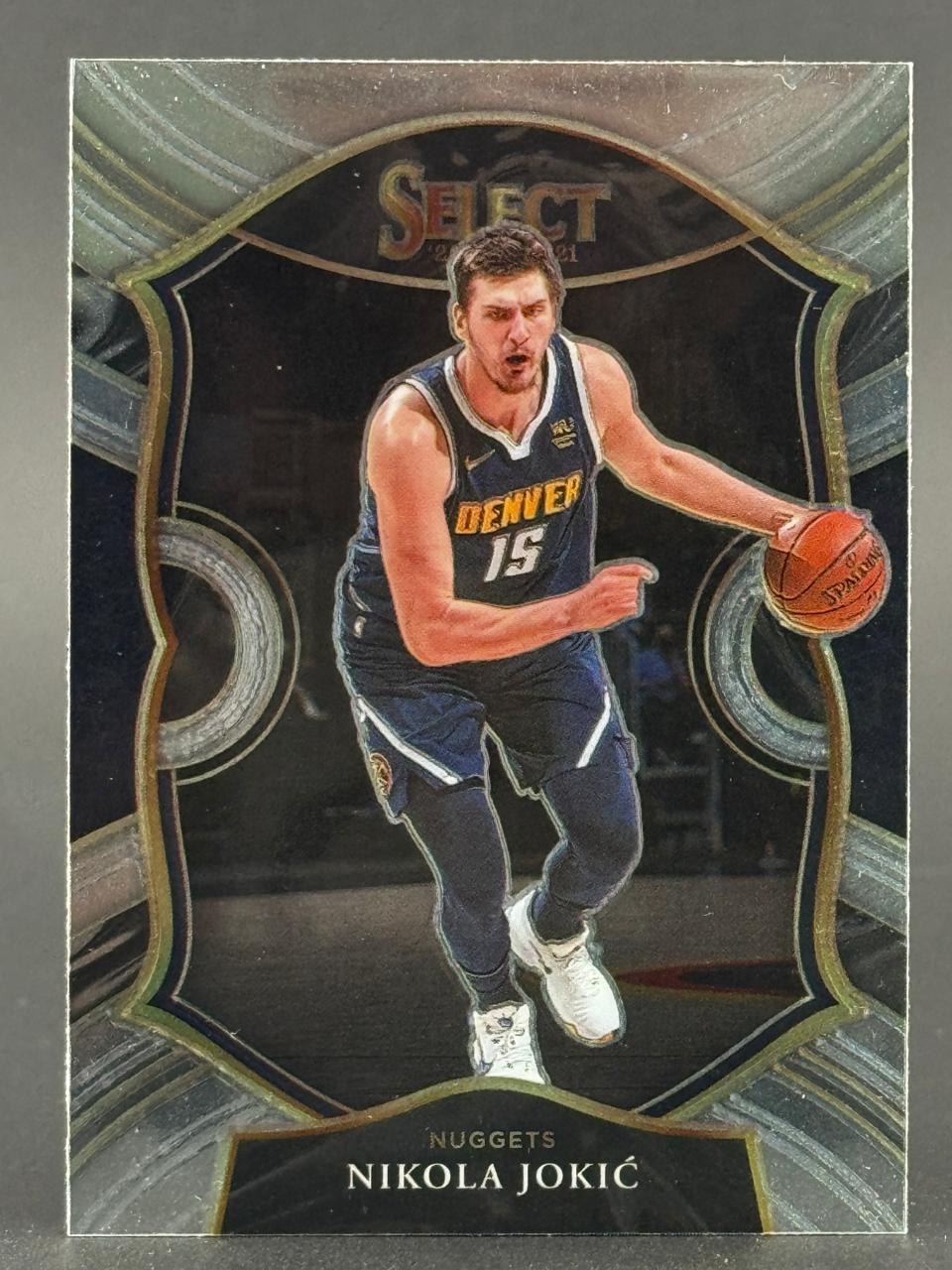 2020-21 Select Nikola Jokic basketball card featuring the Denver Nuggets player dribbling a ball.