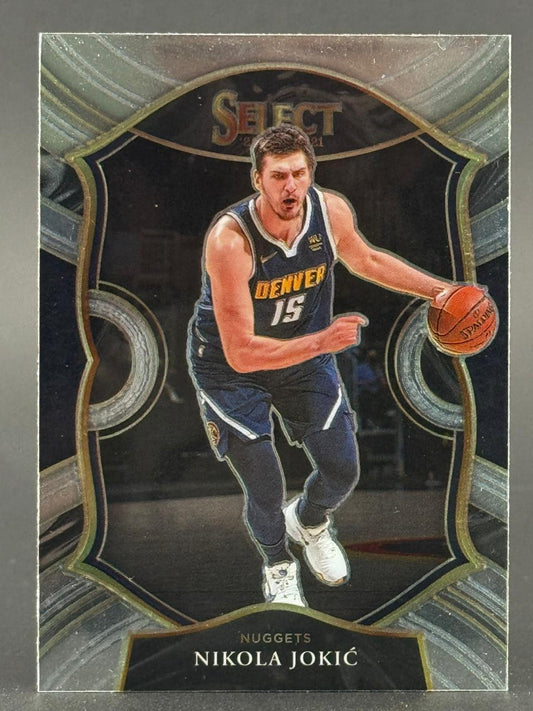 2020-21 Select Nikola Jokic basketball card featuring the Denver Nuggets player dribbling a ball.