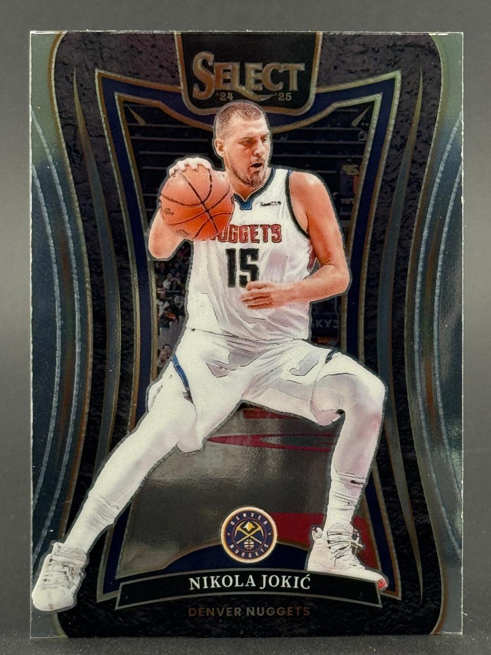 2024-25 Select Nikola Jokić trading card featuring him in a white Nuggets uniform holding a basketball.