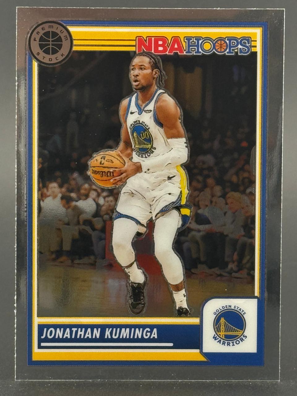 Jonathan Kuminga holding a basketball on a 2021-22 NBA Hoops Premium Stock trading card.