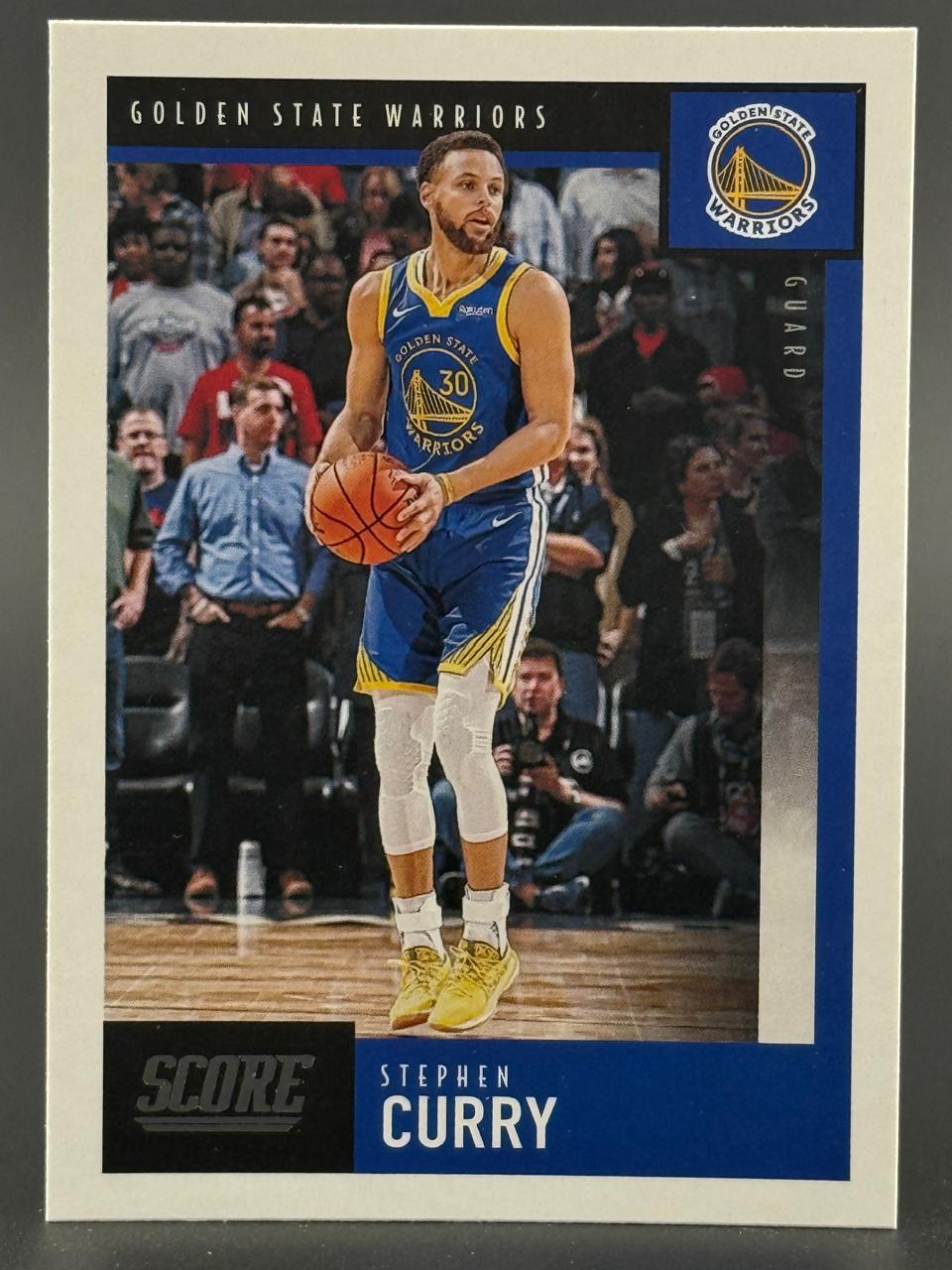 Stephen Curry 2021-22 Score basketball card, number 130, showing him in a blue Warriors uniform holding a ball.