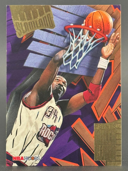 1995-96 NBA Hoops Slamland Hakeem Olajuwon trading card dunking a basketball.