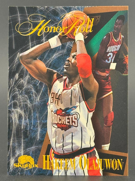 Hakeem Olajuwon SkyBox Honor Roll basketball card featuring two images of the player in Rockets uniforms.