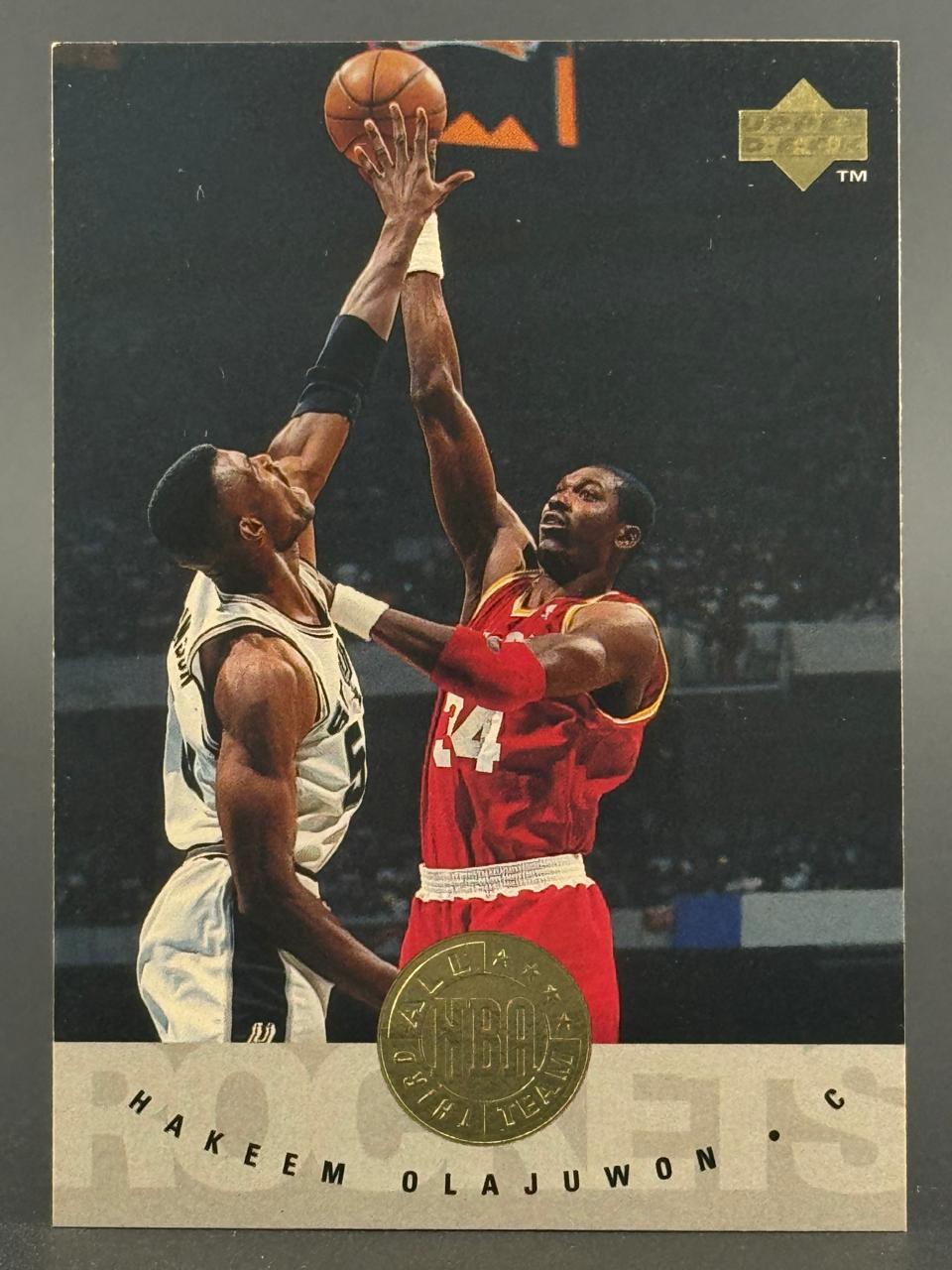 Trading card featuring Hakeem Olajuwon of the Houston Rockets playing against David Robinson.