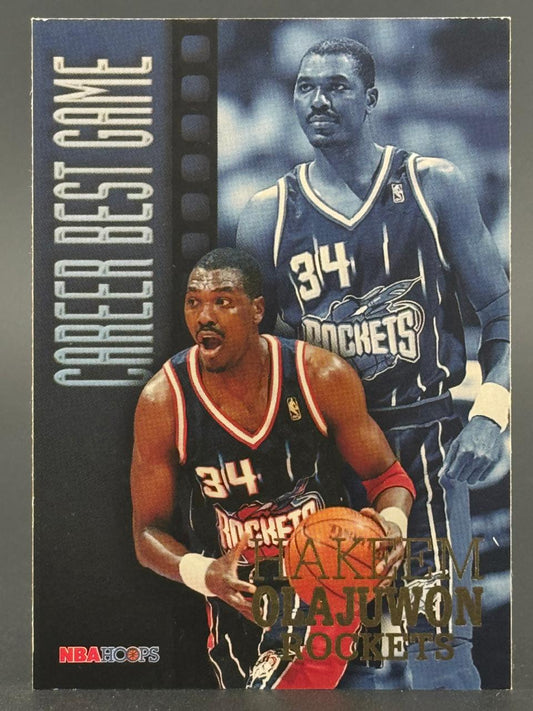 1996-97 NBA Hoops Hakeem Olajuwon Career Best Game trading card featuring two images of the player in a Rockets uniform.
