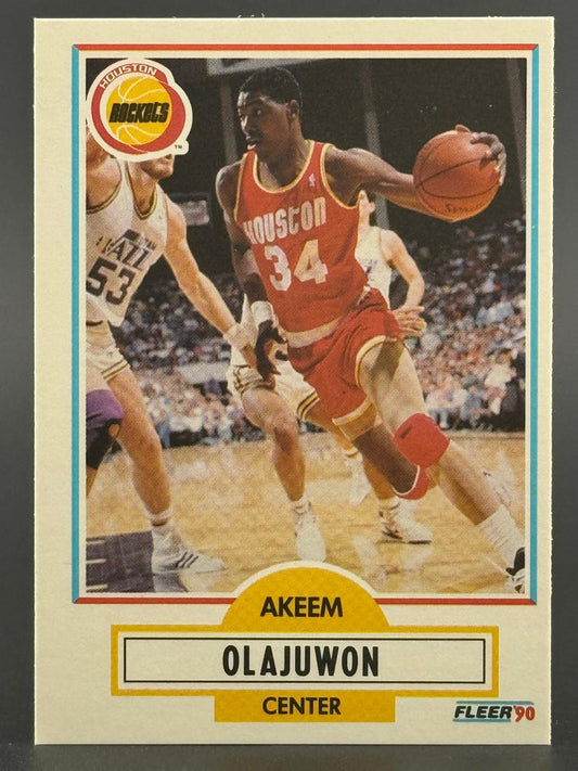 1990 Fleer Akeem Olajuwon basketball card #34, showing him dribbling in a red Houston Rockets uniform.