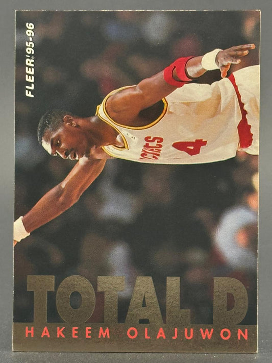 1995-96 Fleer Total D Hakeem Olajuwon basketball card #4, showing him in a Houston Rockets uniform.