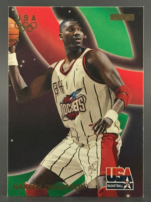 Hakeem Olajuwon basketball trading card showing him holding a basketball.