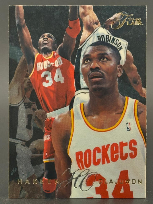 1995-96 Flair Hakeem Olajuwon basketball card featuring action shots and close-up of the player in Rockets jersey.