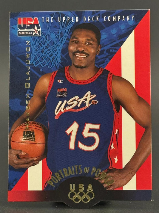Hakeem Olajuwon 1992 Upper Deck USA Basketball trading card showing him in a USA jersey holding a basketball.