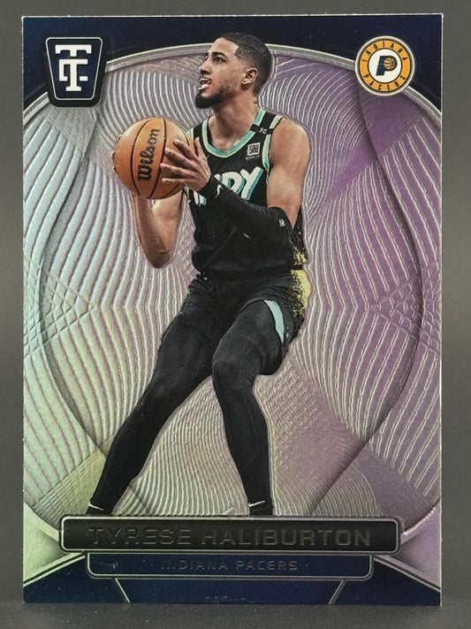 Tyrese Haliburton trading card, holding basketball, in Pacers uniform against a purple patterned background.