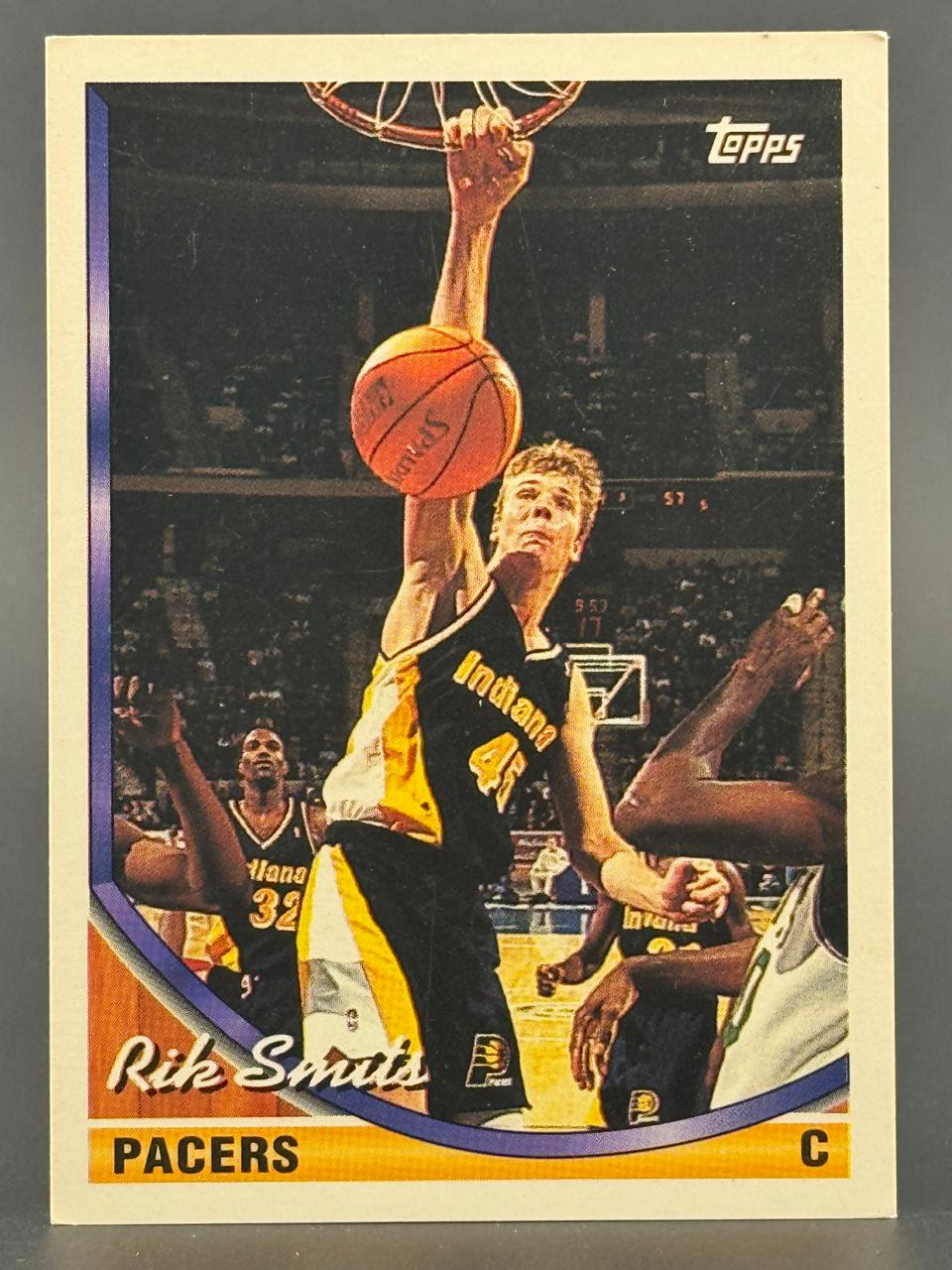 Rik Smits Topps basketball card, showing him dunking a basketball in a Pacers uniform.