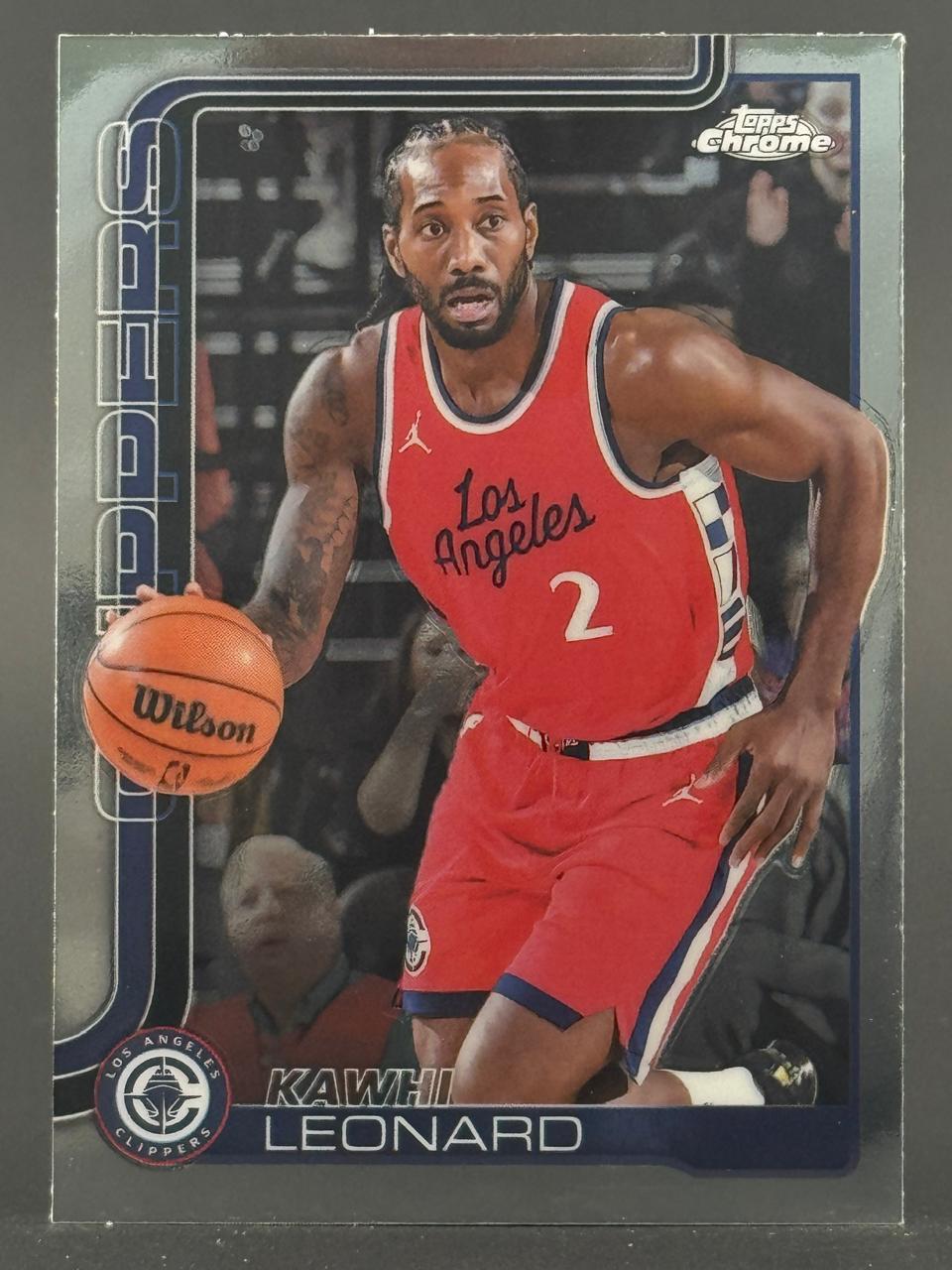 Kawhi Leonard Topps Chrome trading card, showing him dribbling a basketball in a red Los Angeles Clippers jersey.