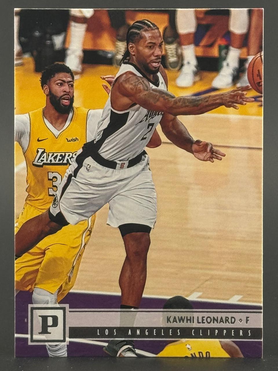Kawhi Leonard basketball trading card, showing him in a Clippers uniform defending against Anthony Davis.