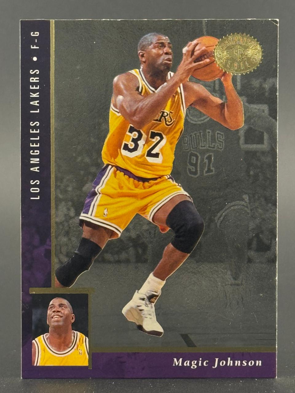 Trading card of Magic Johnson in a Lakers jersey with a gold seal in the upper right.