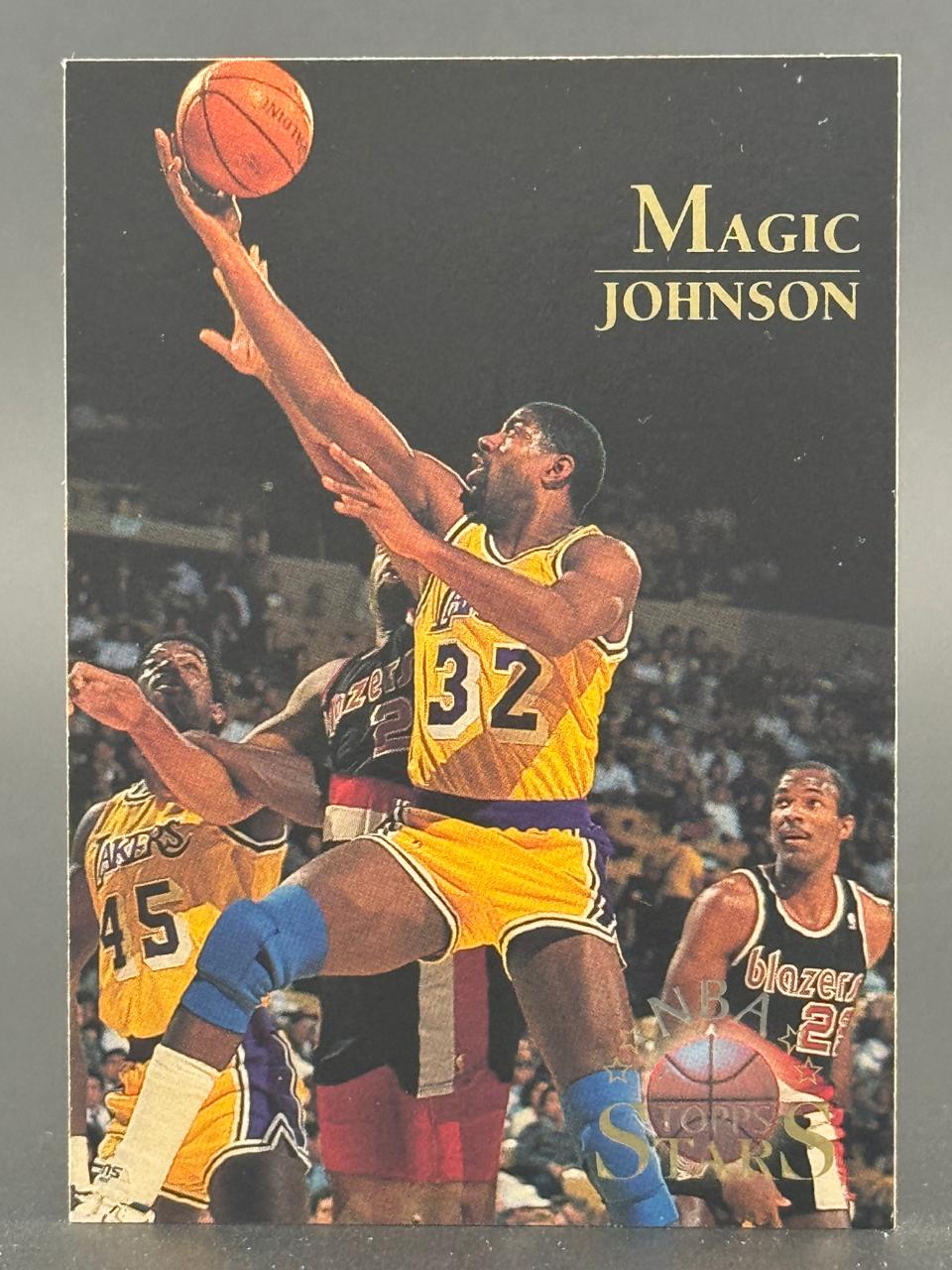 Magic Johnson basketball trading card with him shooting a basketball, wearing a yellow Lakers jersey.