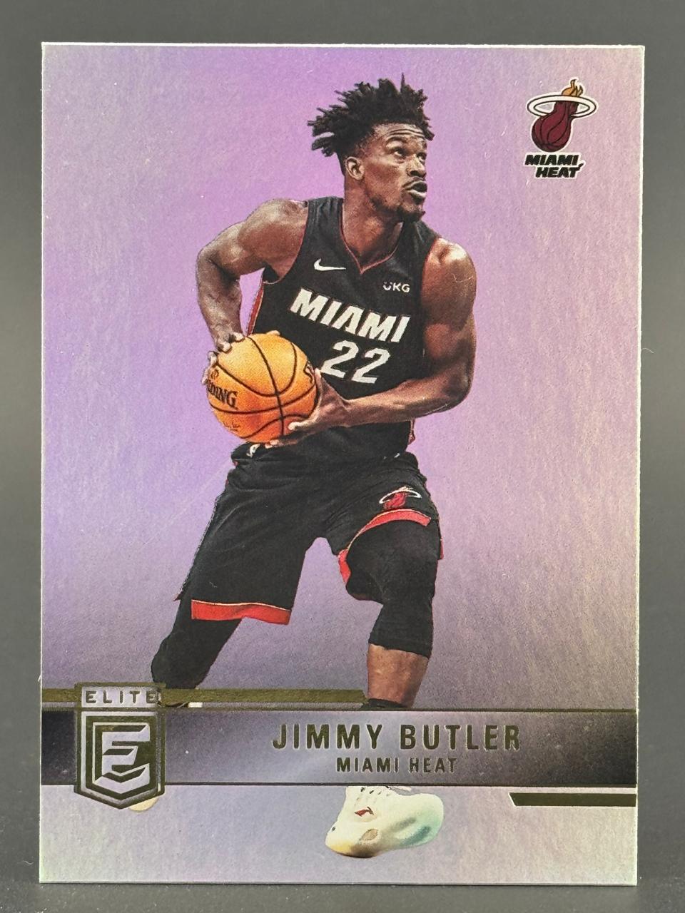 Jimmy Butler 2021-22 Panini Elite basketball card holding a ball.