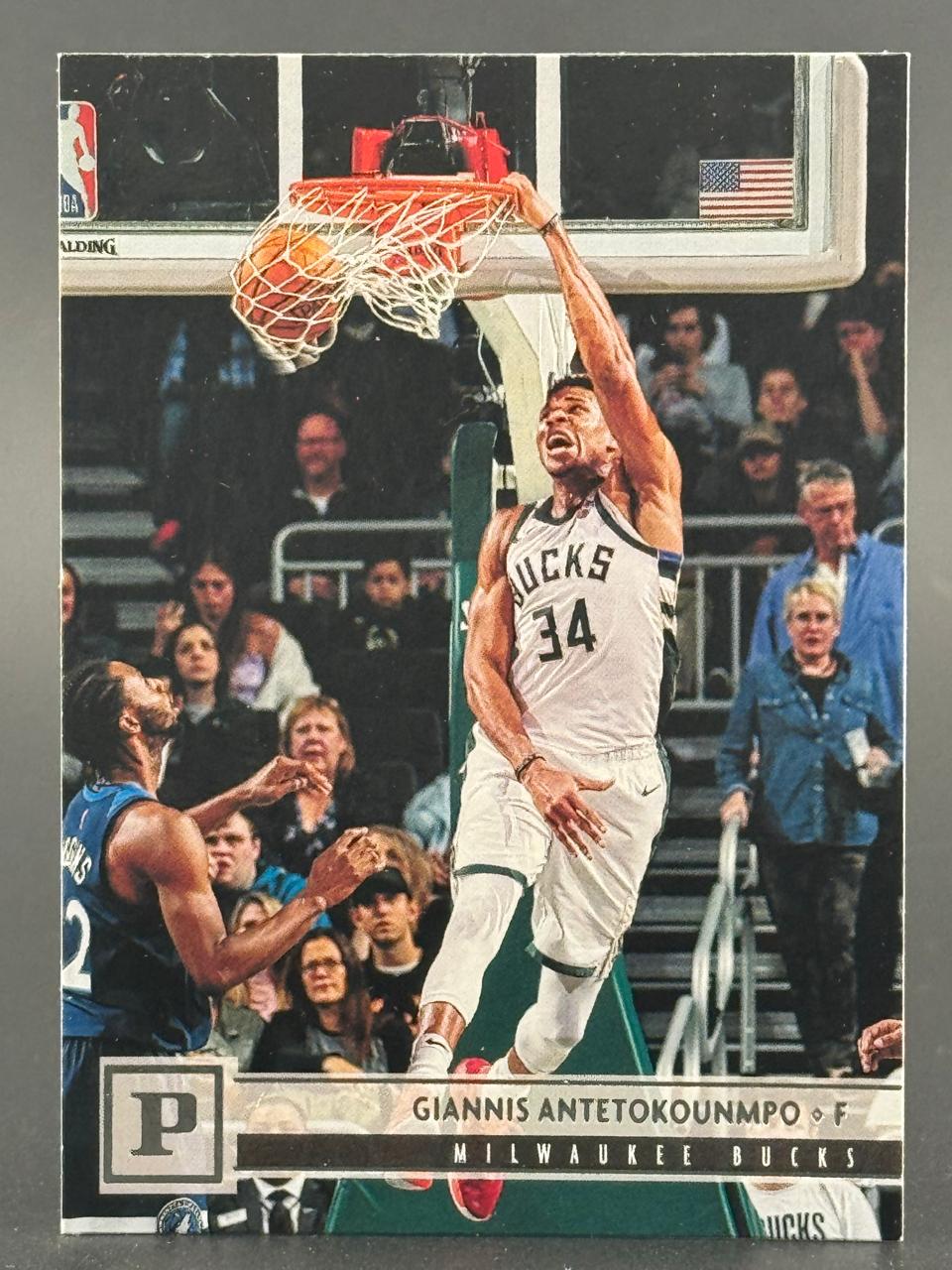 Giannis Antetokounmpo basketball trading card showing him dunking in a Milwaukee Bucks uniform.