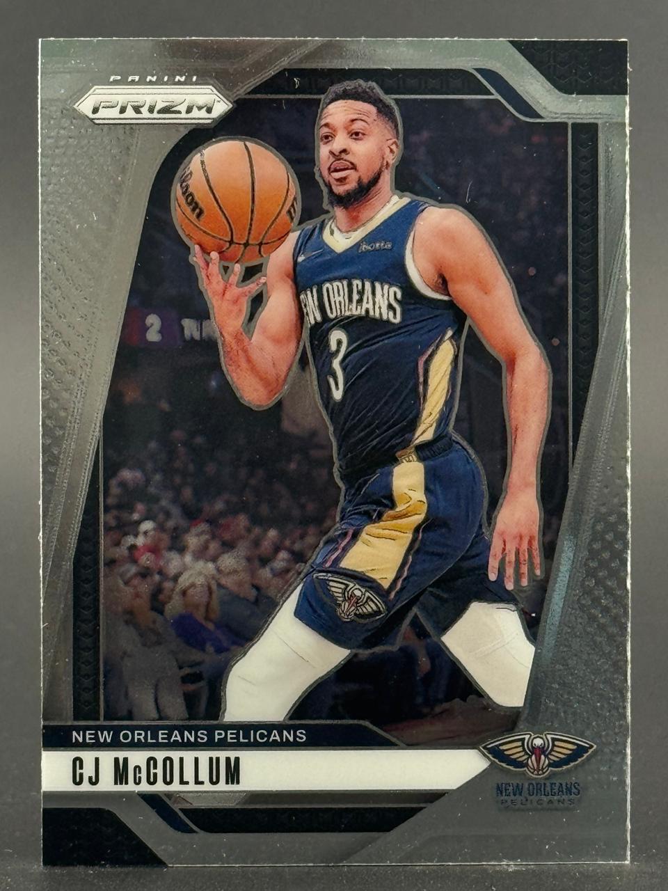 CJ McCollum on a Panini Prizm trading card, wearing a New Orleans Pelicans uniform and holding a basketball.