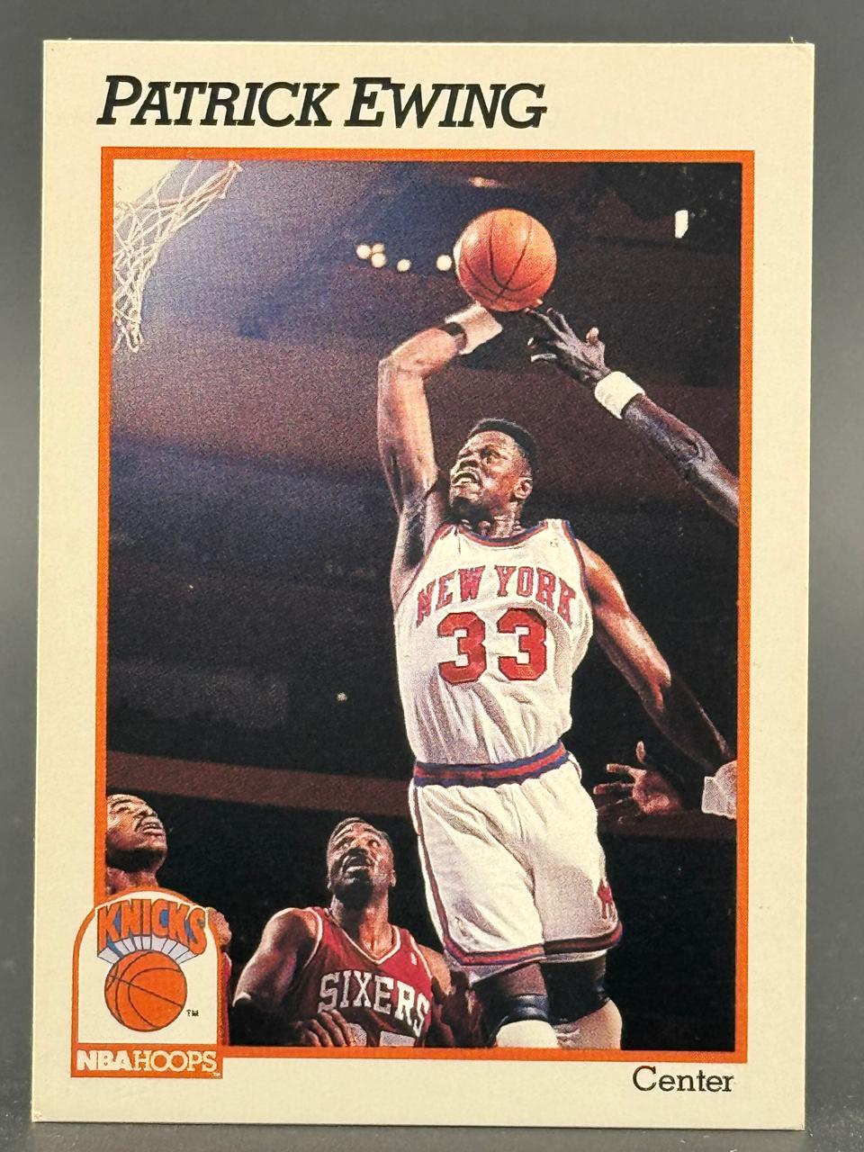 1989-90 NBA Hoops Patrick Ewing basketball card #33, showing him shooting a jump shot over a defender.
