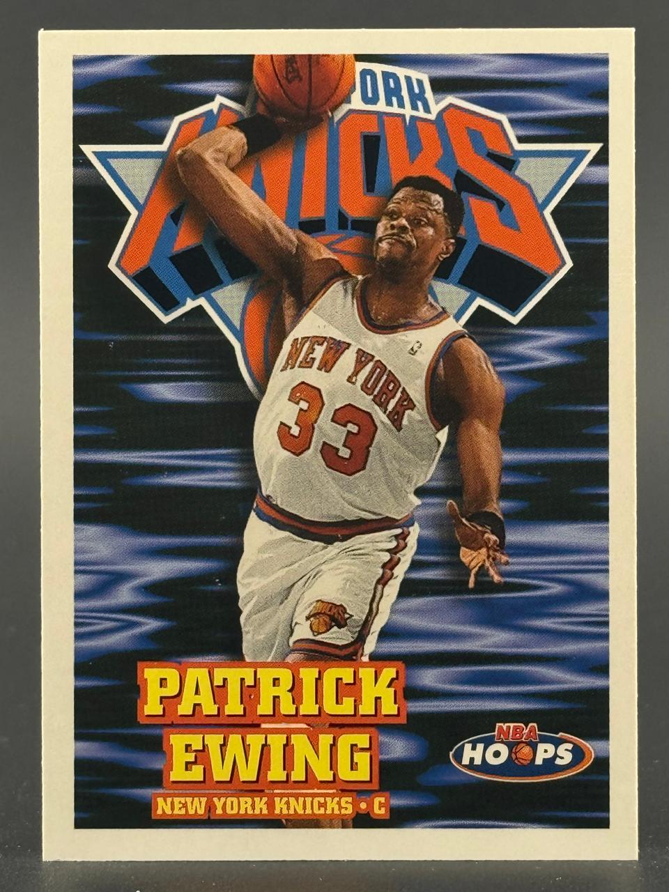 Patrick Ewing 1993-94 NBA Hoops trading card, showing Ewing in a Knicks uniform preparing to dunk.