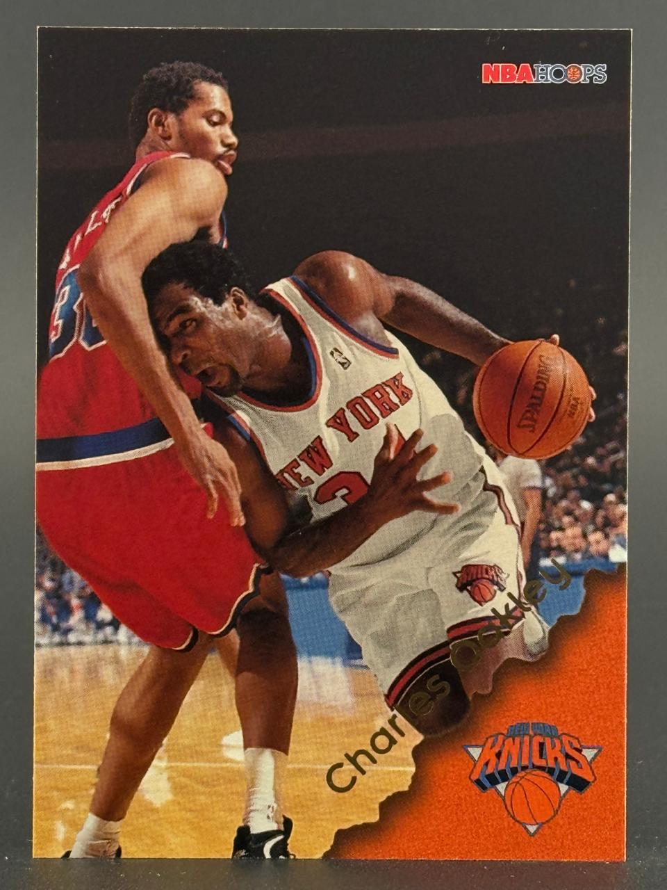 1990-91 NBA Hoops basketball card featuring Charles Oakley of the New York Knicks dribbling past a defender.