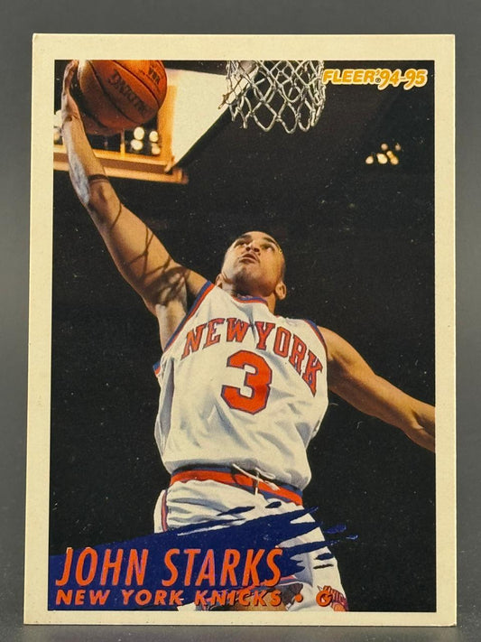 1994-95 Fleer John Starks basketball card showing Starks dunking for the New York Knicks.