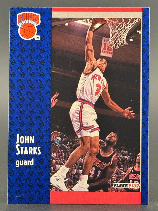 1991-92 Fleer John Starks trading card featuring him dunking in a New York Knicks uniform.