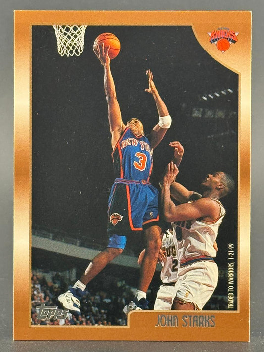 John Starks 1998-99 Topps basketball card, gold border, going for a layup in a New York Knicks uniform.