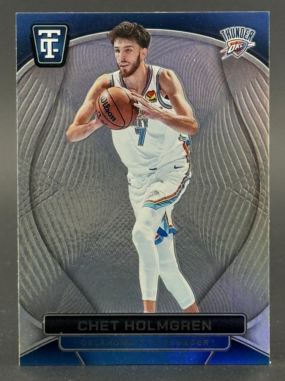 Chet Holmgren basketball trading card featuring him in his Oklahoma City Thunder uniform holding a basketball.