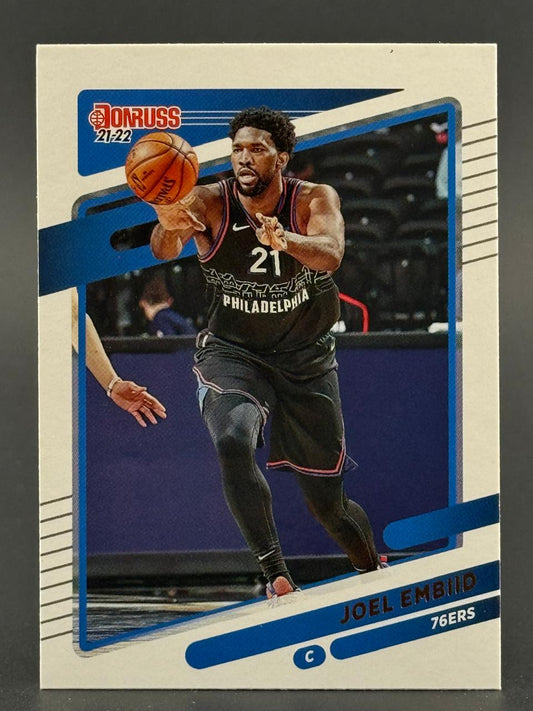 2021-22 Donruss Joel Embiid #21 basketball card featuring him passing the ball in a 76ers uniform.