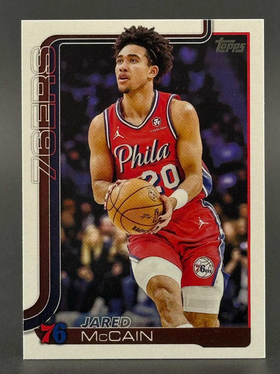 Jared McCain Topps basketball card, holding a ball in a red 76ers uniform.