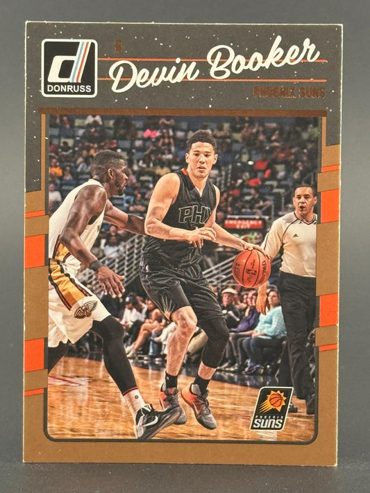 Devin Booker 2016-17 Donruss basketball card featuring him dribbling in a game.