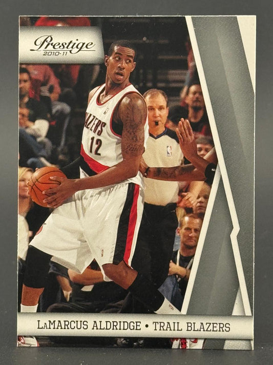 2010-11 Prestige LaMarcus Aldridge basketball card featuring him in a Trail Blazers uniform with a basketball.