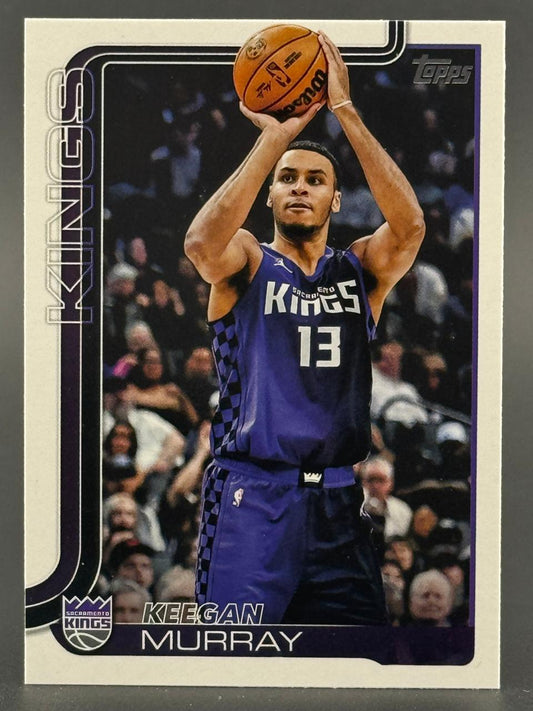 Trading card of Keegan Murray in a purple Sacramento Kings uniform, holding a basketball above his head.