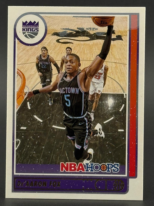 De'Aaron Fox 2021-22 NBA Hoops basketball card featuring Fox dunking in a Sacramento Kings uniform.