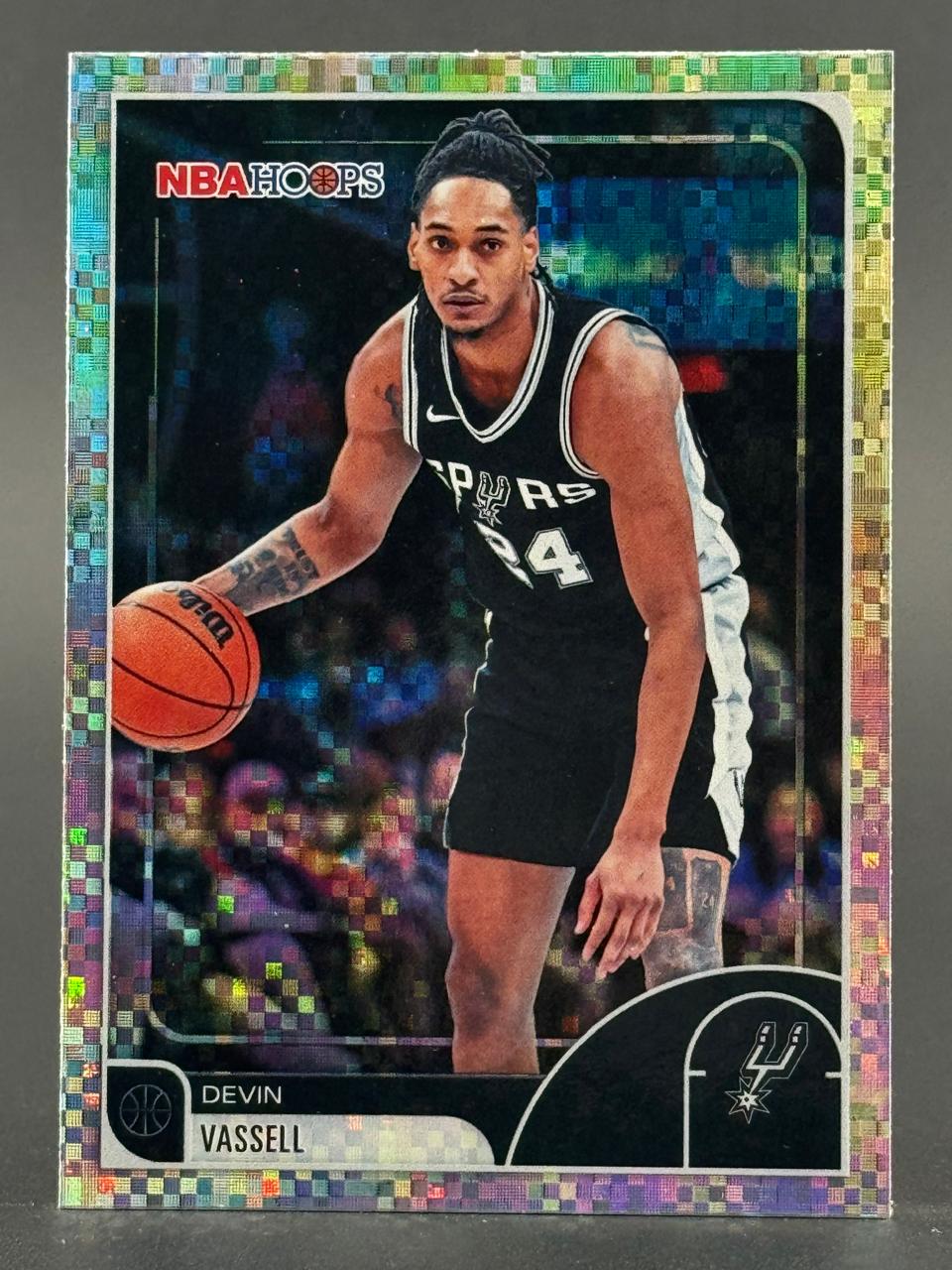 Devin Vassell trading card, NBA Hoops, showing him dribbling a basketball in a Spurs uniform with a foil border.