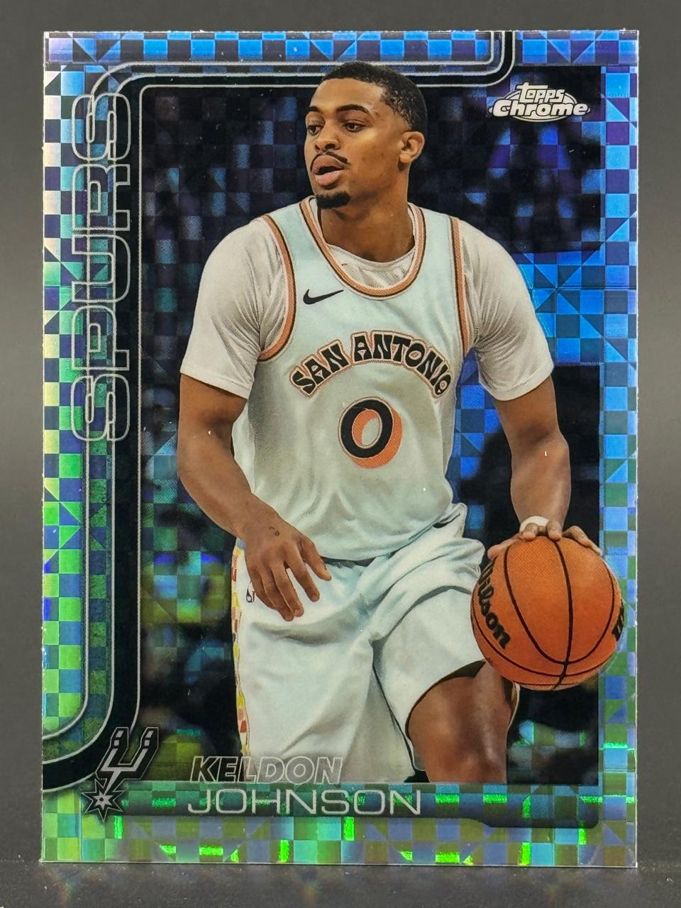 Trading card of Keldon Johnson in a Topps Chrome set, dribbling a basketball with a blue checkered background.