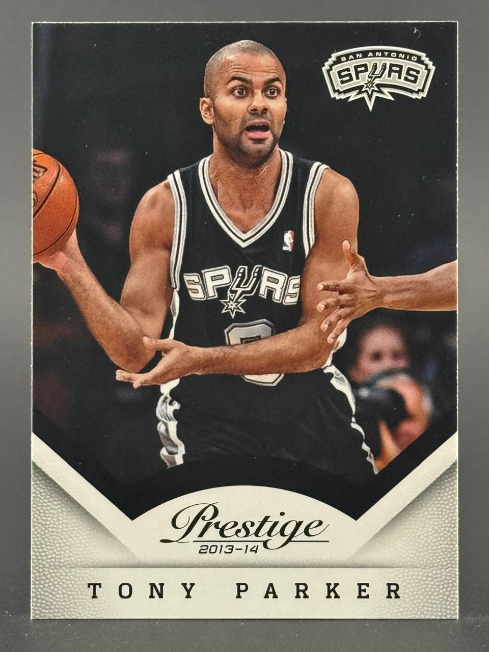 2013-14 Prestige basketball card of Tony Parker dribbling in his San Antonio Spurs uniform.