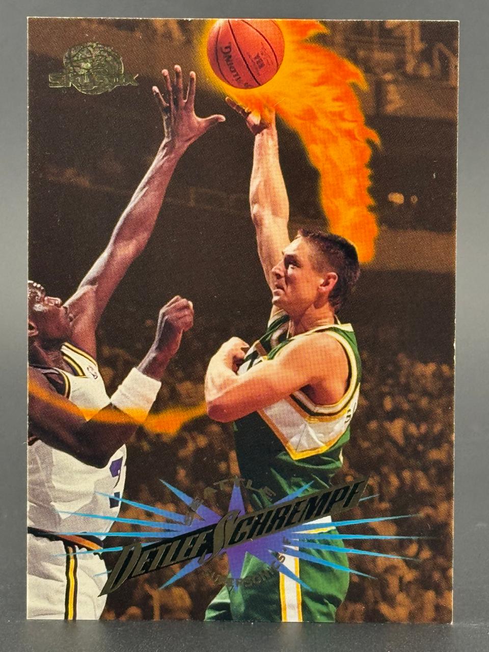 1990s Detlef Schrempf trading card featuring him shooting a flaming basketball past a defender.