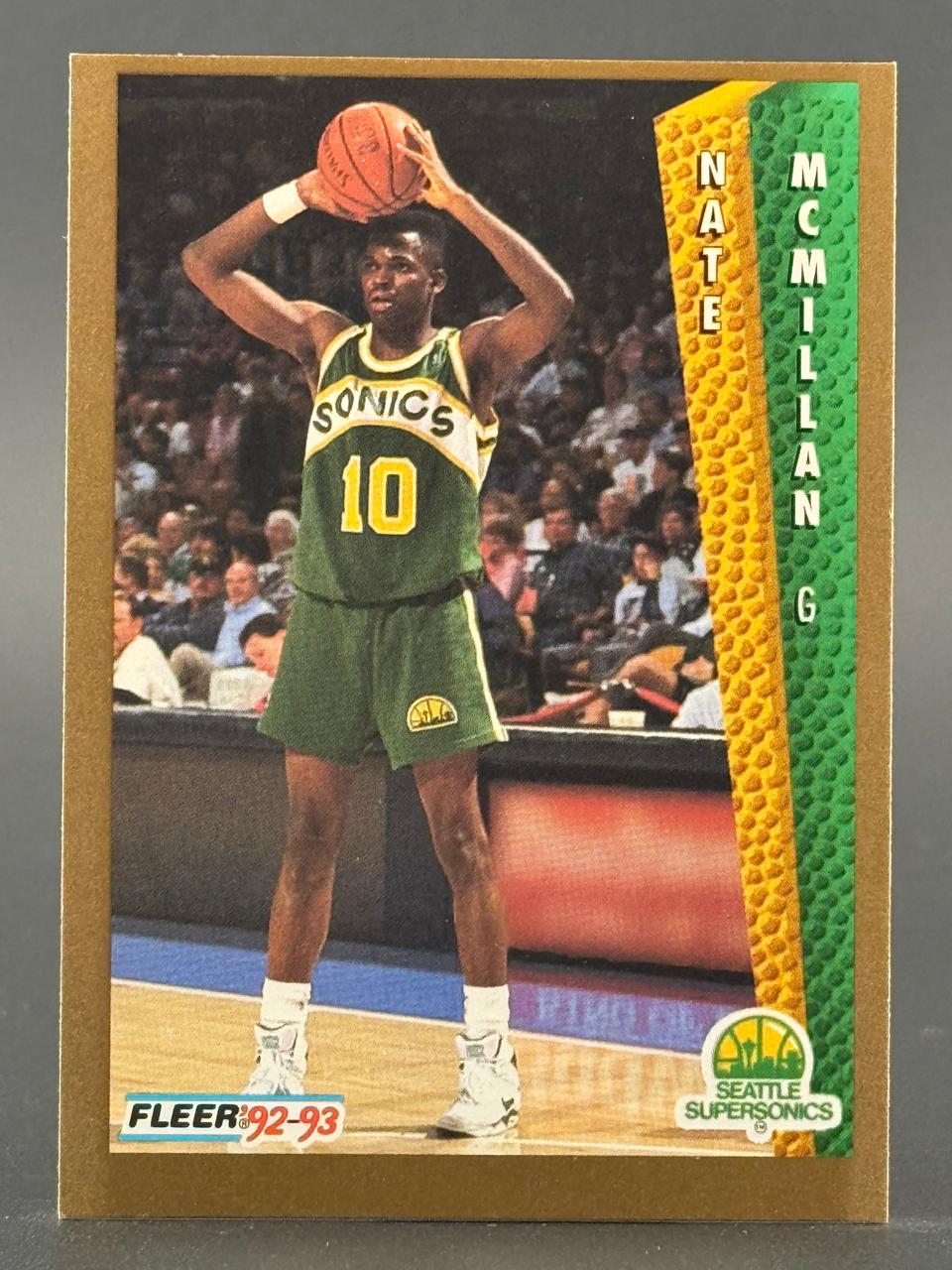 1992-93 Fleer Nate McMillan #N/A basketball trading card featuring him holding a ball in a Sonics uniform.
