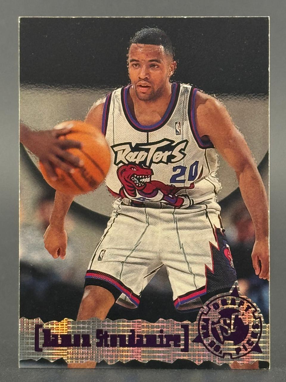 Damon Stoudamire trading card featuring him dribbling in a Toronto Raptors uniform.